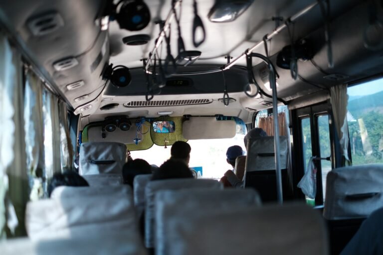 Passengers on a long-distance bus with green countryside through the windows